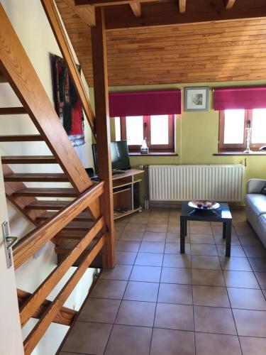 a living room with a staircase and a table at Les Gîtes "Le Petit Val" in Durbuy