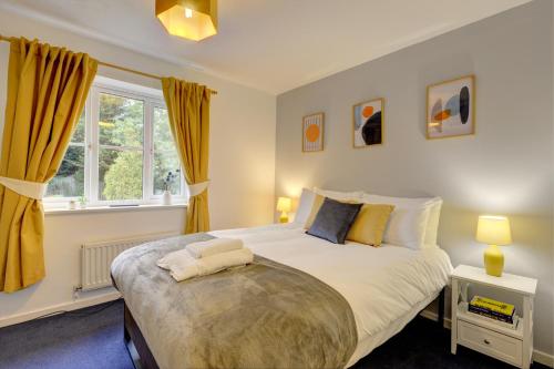 - une chambre avec un grand lit et des rideaux jaunes dans l'établissement Modern 2 Bed House Sleeps 6 Southam Town Centre - Inspire Homes Ltd, à Southam