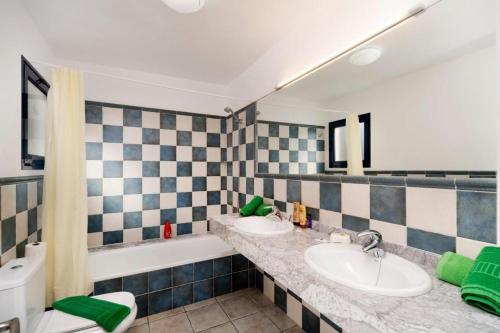 a bathroom with two sinks and a bath tub at Coloradas Villa Alba in Playa Blanca