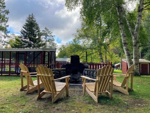 a group of chairs sitting in front of a grill at The Lorca Adirondacks Motel in Indian Lake