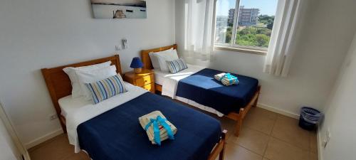 two beds in a small room with a window at Varandas de Carteia in Quarteira
