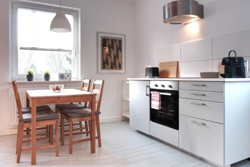 a kitchen with a table and chairs and a stove at Schicke & helle Wohnung in Mülheim an der Ruhr in Mülheim an der Ruhr