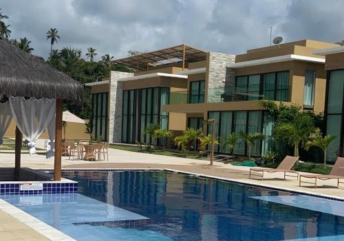 um resort com piscina e um edifício em Casa Milagres Morada do Toque l Prêmio travellers choice 2023 em São Miguel dos Milagres