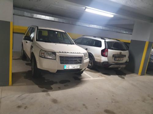 two white cars parked in a parking garage at apartman Kraljevi čardaci Sadikovic sa garažom in Kopaonik