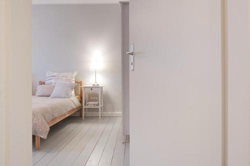 a bedroom with a bed and a table with a lamp at Schicke & helle Wohnung in Mülheim an der Ruhr in Mülheim an der Ruhr