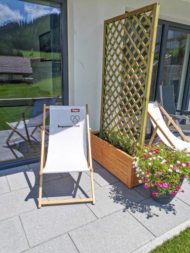 two lawn chairs and a sign on a patio at Apart Wachter in Fendels