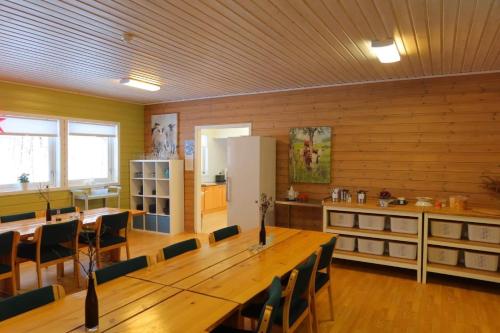 a large room with a wooden table and a kitchen at Fosseland Gjestegård in Feda