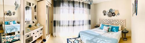 a bedroom with a bed and a large window at Mangroovy - Elgouna Authentic Designer shared home 2 BDR each with private bathroom for Kitesurfers with Pool View & Beach Access in Hurghada