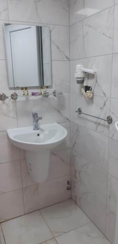 a white bathroom with a sink and a mirror at Elijah Hotel in Kemer