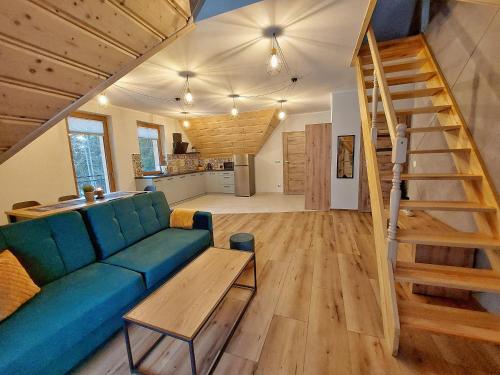 a living room with a blue couch and a wooden floor at Apartamenty Słodyczki in Nowe Bystre