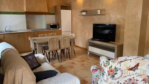 a living room with a couch and a table with a television at Casa sala pinta in Castellfort