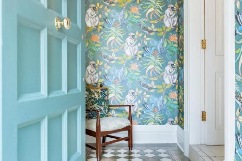 a chair in a hallway with a blue wallpaper at Blackpool Abode - Southlands in Blackpool