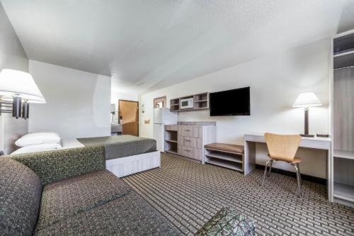 a hotel room with a bed and a desk and a couch at Bearcat Inn and Suites in Maryville