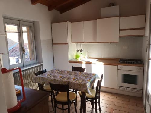 eine Küche mit einem Tisch und Stühlen sowie einem Tisch und einem Tisch und einer Küche in der Unterkunft Pavia Downtown Apartment in Pavia