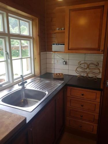 a kitchen with a sink and a window at Pine Cabin, Strathyre. A cosy escape from it all. in Strathyre