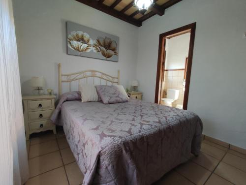 ein Schlafzimmer mit einem Bett, einer Kommode und einem Spiegel in der Unterkunft Casa Juanse in Conil de la Frontera