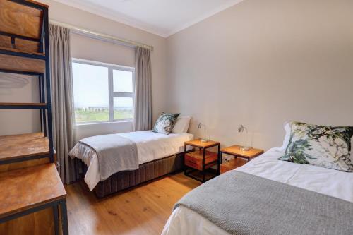 a hotel room with two beds and a window at Out of Bounds Self-Catering Lodge in George