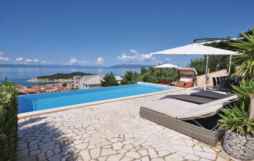 a swimming pool with a bed and an umbrella at Luxury villa with heated pool, jacuzzi and sauna in Makarska