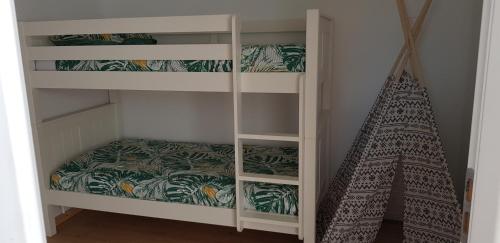 a bedroom with bunk beds with a ladder and a teepee at GITE EN CAMPAGNE 15 min de Rennes in Saint-Gilles