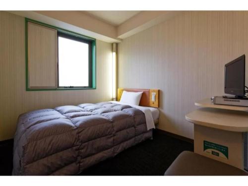 Habitación de hotel con cama y TV en R&B Hotel Kumamoto Shimotori - Vacation STAY 39080v, en Kumamoto