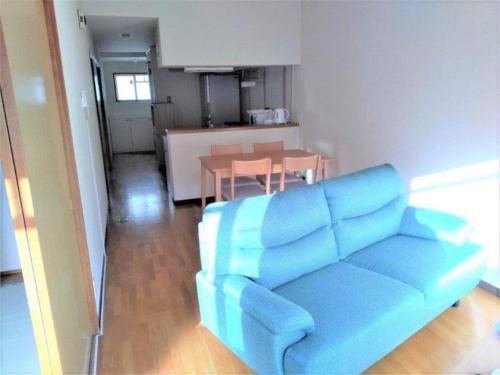 a living room with a blue couch and a table at Maison Ota Building A Building B - Vacation STAY 12386 in Takamatsu