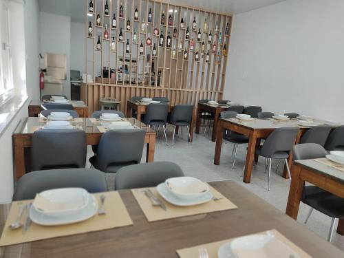 a dining room with tables and chairs with plates on them at Olhar Sobre o Alva - Turismo Rural e Sabores in São Sebastião da Feira