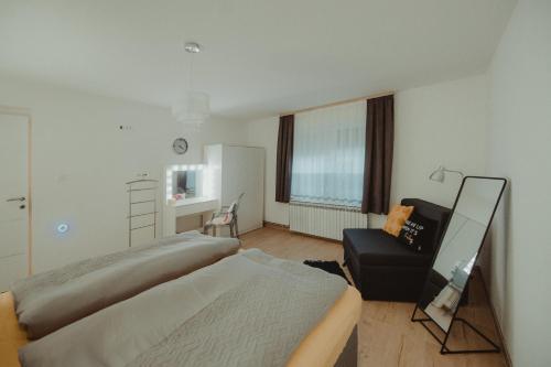 a hotel room with two beds and a chair at Kućica in Đakovo
