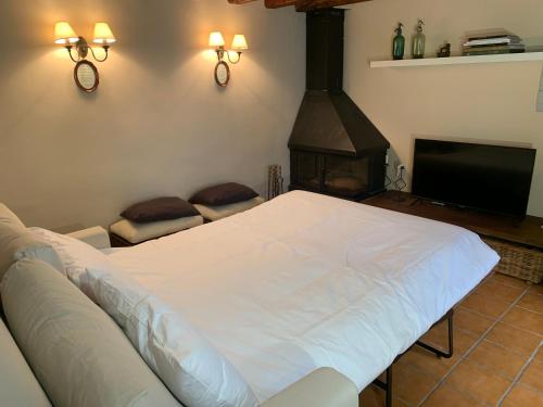 a bedroom with a white bed and a fireplace at Vivienda turística La Caldera in Soria