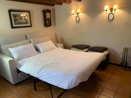 1 dormitorio con 1 cama blanca y 2 sillas en Vivienda turística La Caldera, en Soria