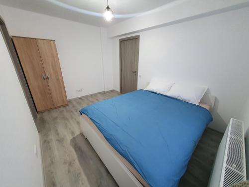- une petite chambre avec un lit bleu et un placard dans l'établissement Apartament 3 cam Grand Arena, à Bucarest