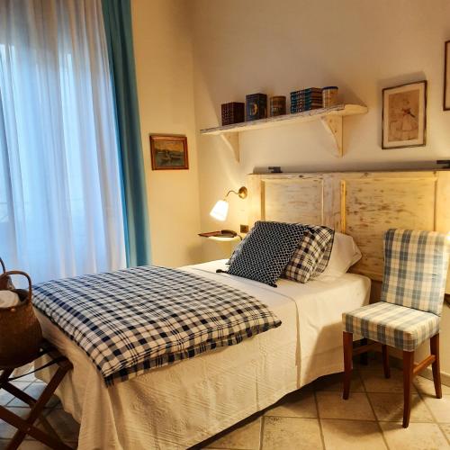 a bedroom with a bed and a chair and a window at Boutique Hotel Fox's Inn in San Giustino Valdarno