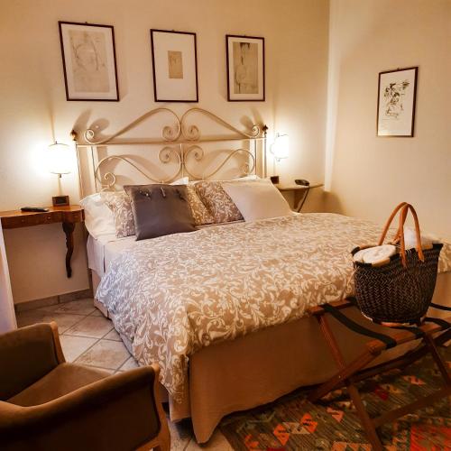 a bedroom with a large bed and a chair at Boutique Hotel Fox's Inn in San Giustino Valdarno