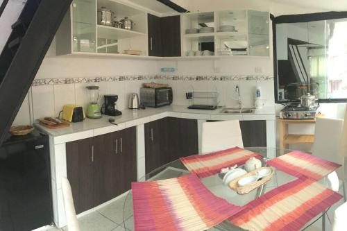 a kitchen with a glass table in a kitchen at Apartamento independiente x6 RegenWasi in Cusco