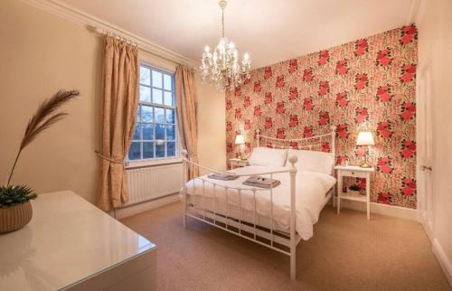 a bedroom with a white bed and a red wall at Choristers Mews: Luxury cottage a stones throw from the Cathedral! in Lincolnshire