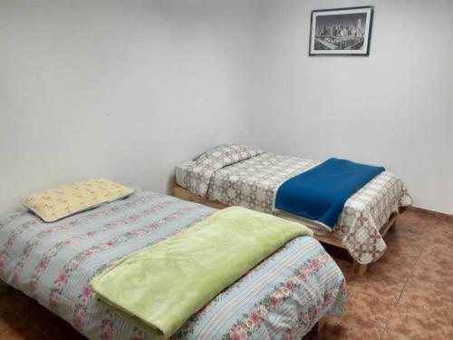Zimmer mit 2 Einzelbetten und einem Bild an der Wand in der Unterkunft Hospedaje San Isidro in Lima
