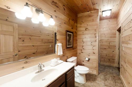 a bathroom with wooden walls and a toilet and a sink at Inspiration Point in Dupont Springs