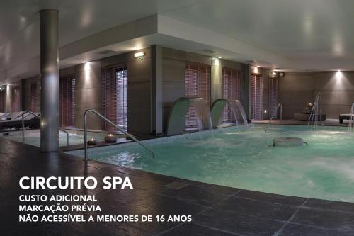 uma grande banheira de hidromassagem num quarto de hotel em Your Hotel & Spa Alcobaça em Alcobaça