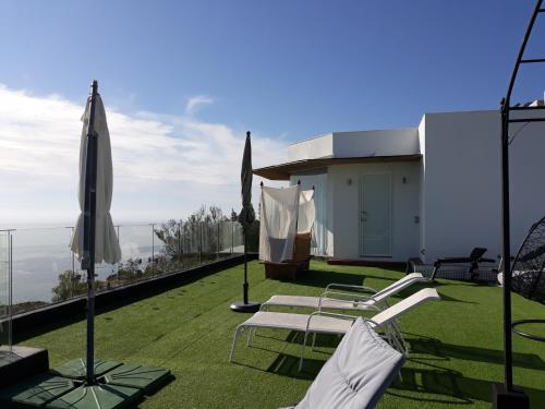 a patio with lawn chairs and an umbrella at Villa Luxury Paradise Suites in Salobreña