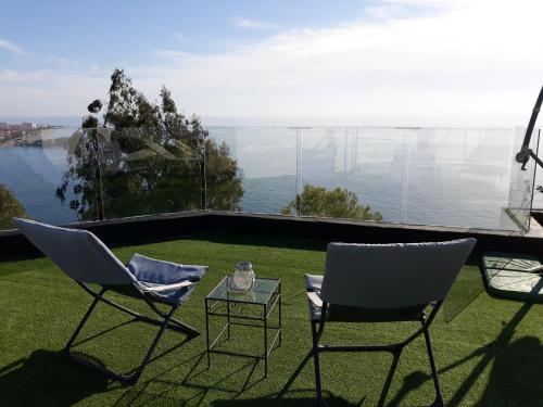 two chairs and a table on a lawn with a view at Villa Luxury Paradise Suites in Salobreña