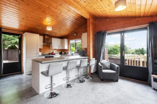 cocina con barra con taburetes en una habitación en Corrie Lodge, Glendevon en Glendevon