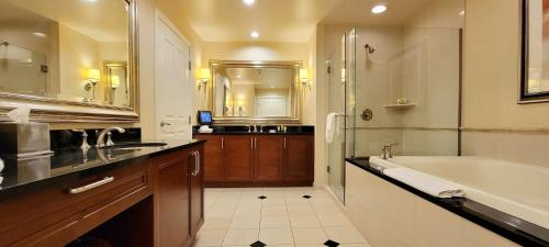 a bathroom with a tub and a sink and a bath tub at Awesome The Signature MGM condo with Strip view. No resort fee! in Las Vegas