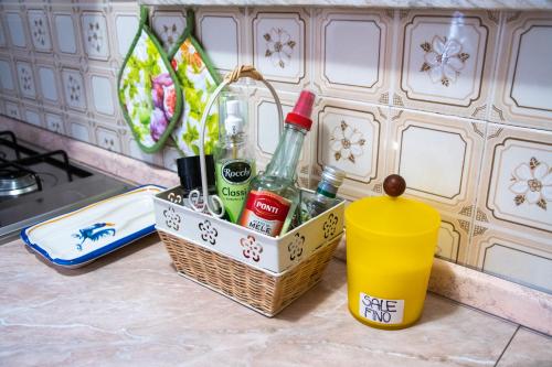 a basket with alcohol bottles and a cup on a counter at Tal Borc in San Vito al Torre