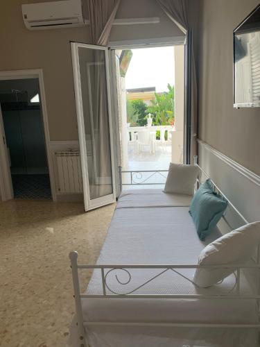 a bedroom with a white bed and a large window at B&B Palma Salentina in Lizzano