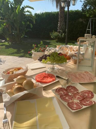 a table with meat and grapes and other food on it at B&B Palma Salentina in Lizzano