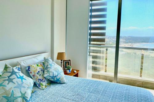 a bedroom with a blue bed with a large window at Apartamento Familiar Vacacional en Puerto Colombia in Puerto Colombia