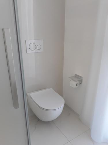 a white bathroom with a toilet in a stall at Villa Luxury Paradise Suites in Salobreña