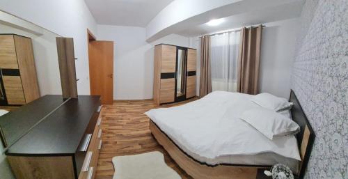 a bedroom with a large bed and a desk at apartament BEST VIEW in Buşteni