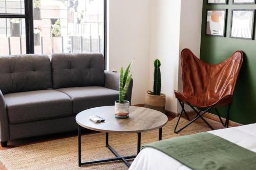 uma sala de estar com um sofá, uma mesa e uma cadeira em Coyote Lofts-Estacion Federal em Tijuana