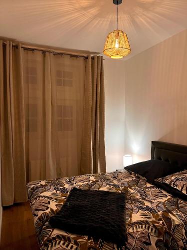 une chambre avec un lit et un lustre dans l'établissement LA BOHÈME, à Troyes