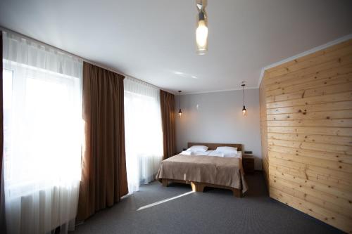 a bedroom with a bed and a wooden wall at Князів Двір in Bukovel